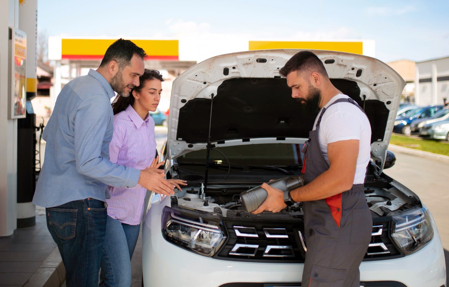 ROAM technician topping up engine oil while customers watch