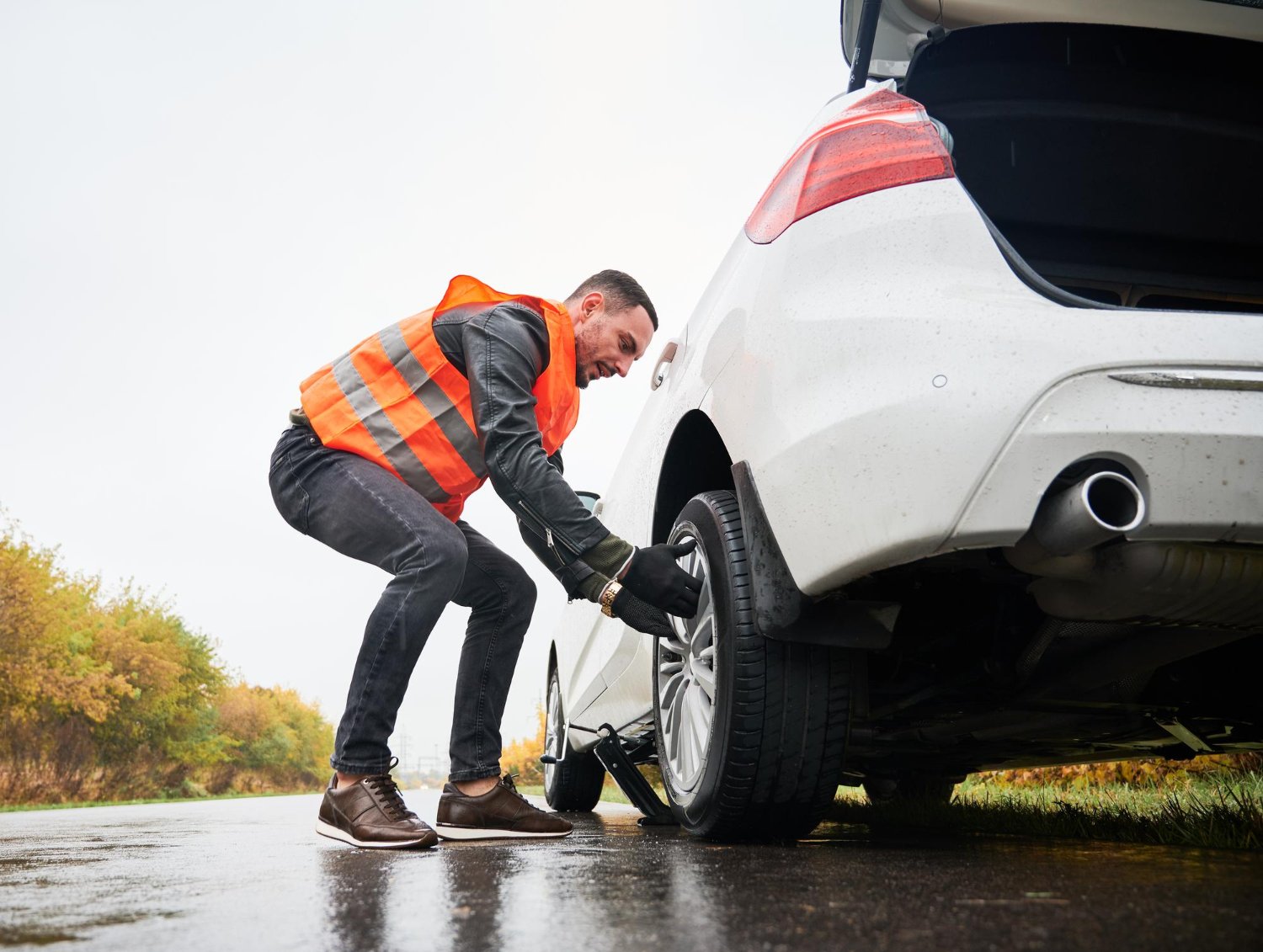 ROAM technician changing a tyre roadside in the rain